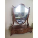 A 19th century mahogany shield shaped toilet mirror with a serpentine three drawer base, in good