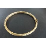 A 9ct yellow gold bangle approx 8.3 grams, 6x7cm - generally good with safety clip