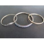 Three silver bangles, one with enamel decoration, approx 34 grams