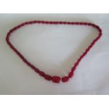 A string of cherry amber Bakelite beads, approx 76cm long, longest bead 2.5x2cm - approx 69 grams