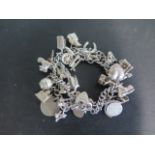 An unusual silver double strand charm bracelet with approx 24 different charms, approx 73 grams