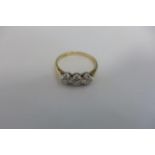 A yellow and platinum three stone diamond ring, an 18ct yellow gold band with a platinum collet, the