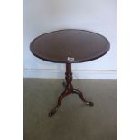 A 19th century mahogany tripod lamp table with dished top in one piece, top supported on turned