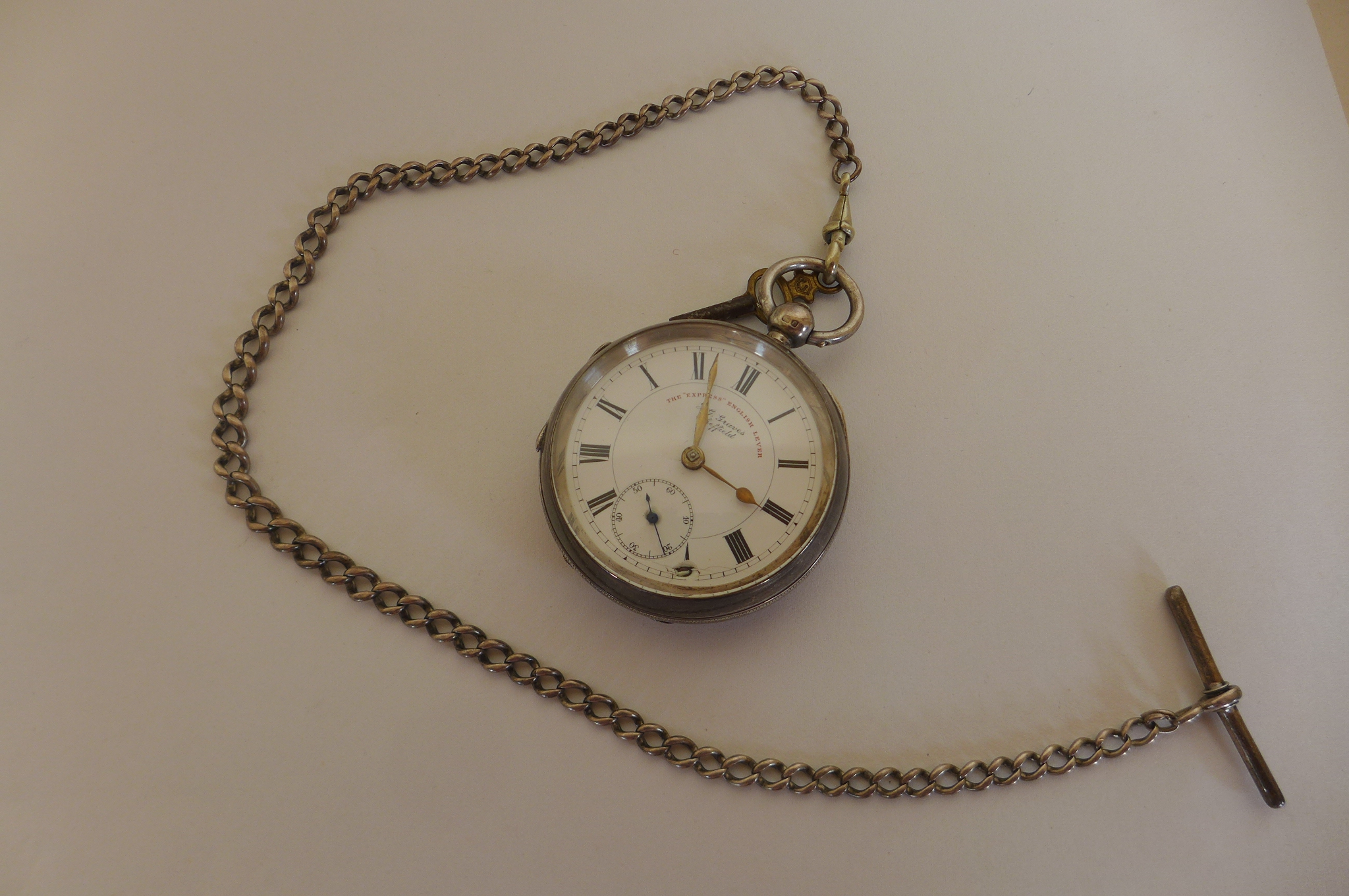 A silver Express English lever pocket watch and silver chain, watch running