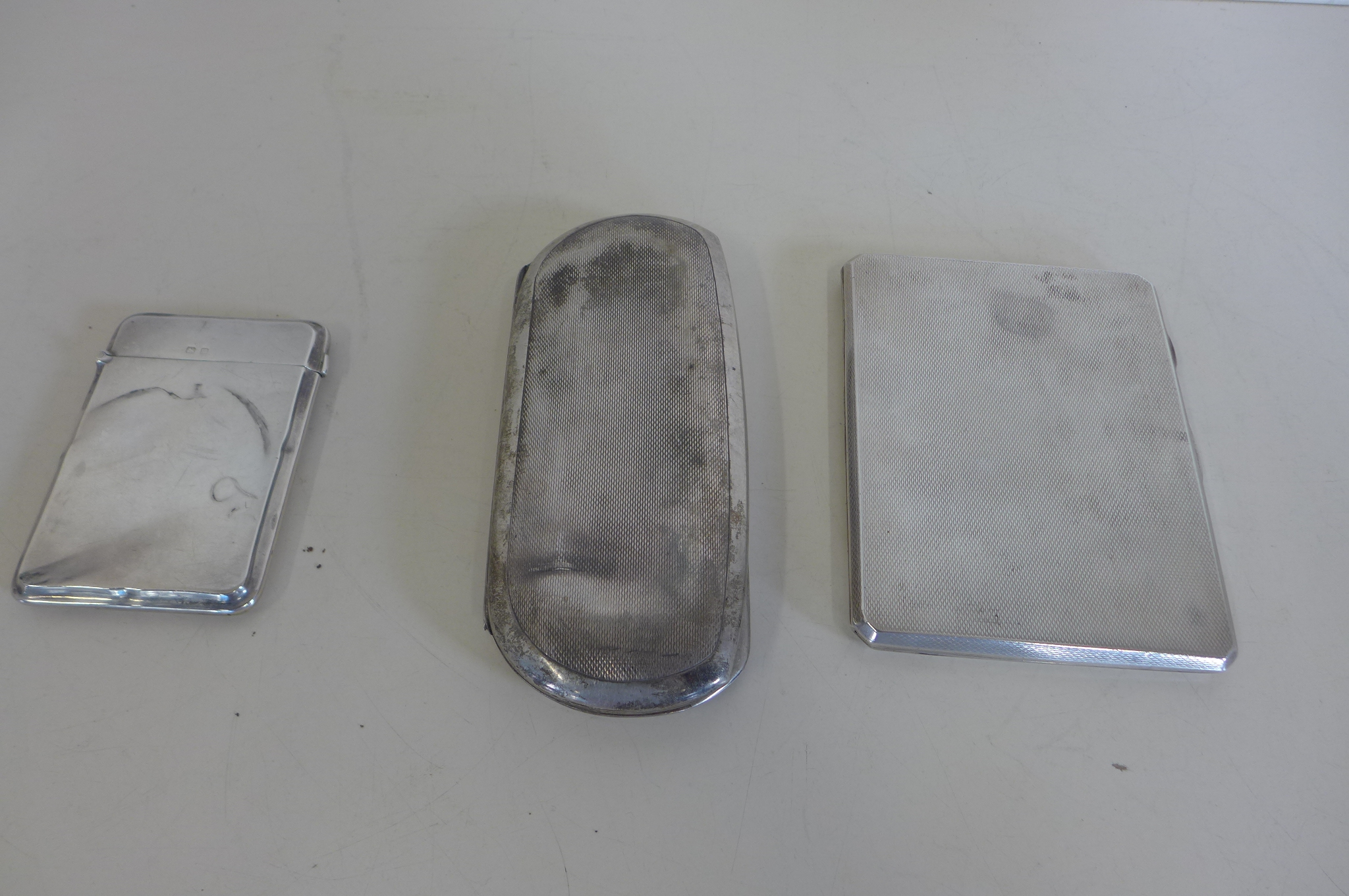 A silver cigarette case, silver card case and silver spectacles case, all with dents, total weight