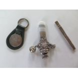 A key ring with silver golfing plaque, a silver rattle teether, and a silver cased nail file