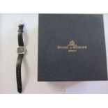 An 18ct white gold ladies Baume and Mercier wrist watch with cabachon sapphire crown, plain black