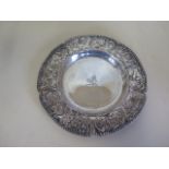 An embossed silver dish with rampant lion and crown mark, embossed with birds and flowers, 14cm
