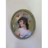 A hand painted porcelain plaque brooch of an attractive lady wearing a hat, 7x6cm, some scratches