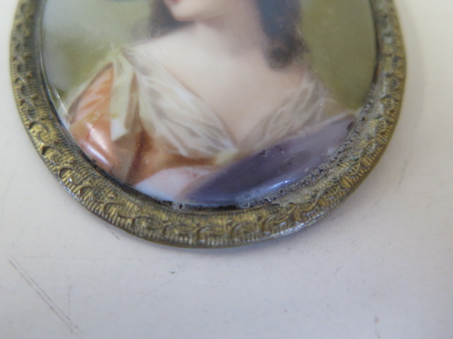 A hand painted porcelain plaque brooch of an attractive lady wearing a hat, 7x6cm, some scratches - Image 2 of 3