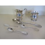 A silver helmet shaped cream jug, a small dented tankard and four pieces of silver flatware,