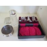 A silver cruet set - boxed, a silver cigarette case, a silver sifter and a silver wine coaster,