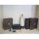 A collection of 19th century large family bibles with ornate brass work as well as religious statues