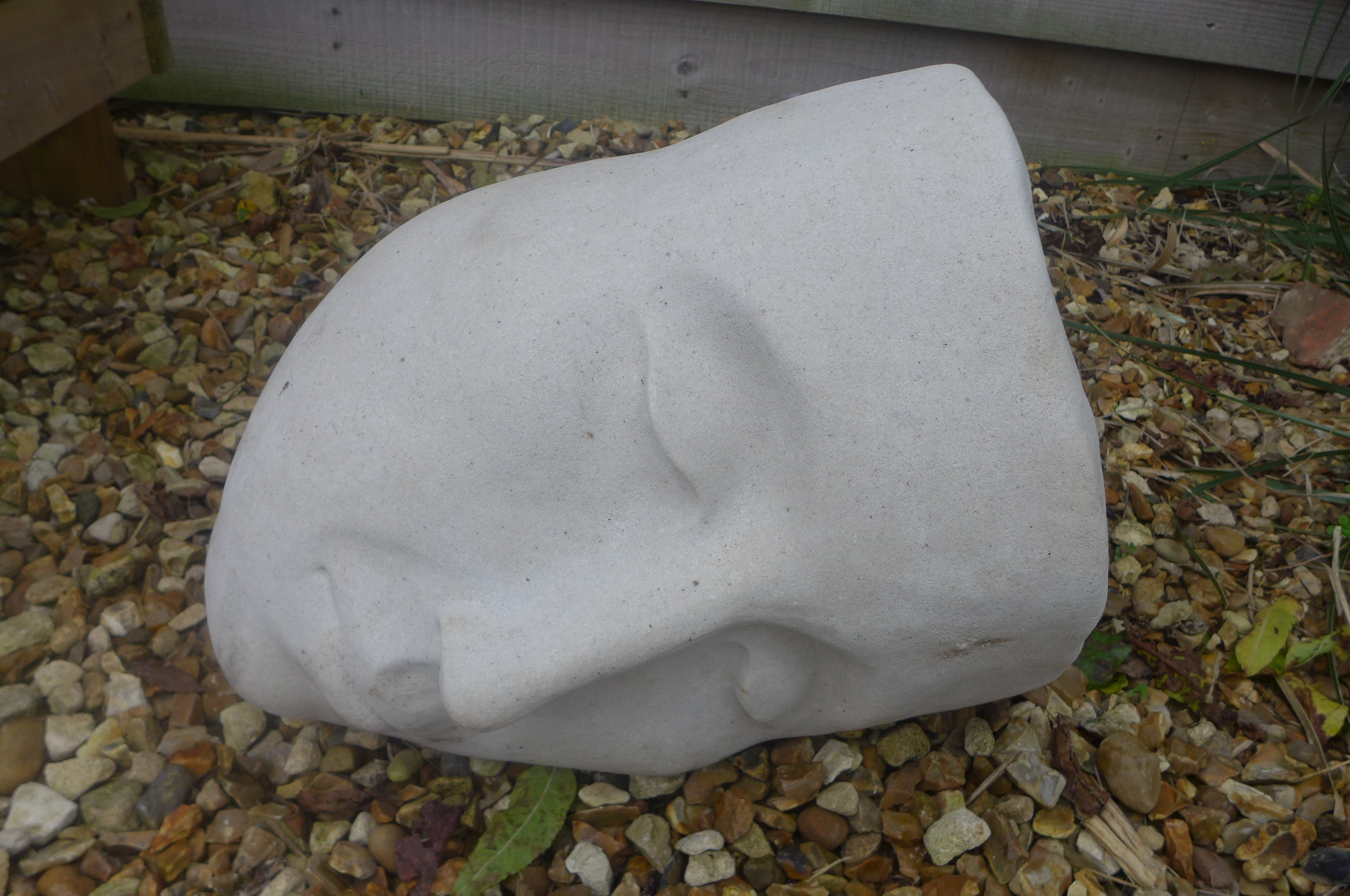 A cast iron stone garden sculpture of a serene sleeping head - 37cm W x 28cm H