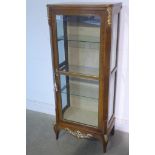 An early 20th century French faded rose wood vitrine, applied with gilt metal mounts, glazed door