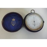 An Elliot Bros of London compensated travel barometer, 7cm diameter in a leather case, needle