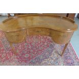A 20th century walnut kidney shaped dressing table with a single frieze drawer flanked by cupboard