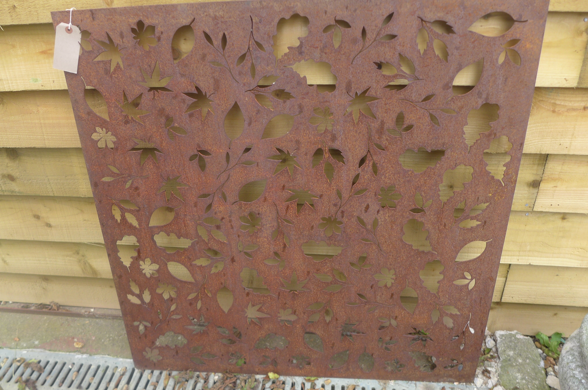 A pierced steel decorative wall panel depicting falling autumn leaves, 99.5cm square