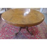 A Victorian walnut oval tilt top loo table in a quatrefoil base, 71cm tall x 107cm x 73cm