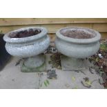 A near pair of stone effect urns, 36cm tall