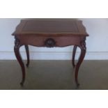A mahogany side table with a shaped top having a leather insert, above a blind drawer, on cabriole