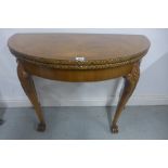 An early 20th century walnut fold over demi lune card table, 74cm H x 92cm W