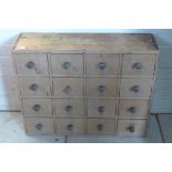 A Victorian bank of sixteen stripped pine chemist drawers, 61cm tall x 77cm x 23cm