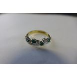 An 18ct diamond and emerald half eternity ring in an unusual stepped design, all stones approx 0.