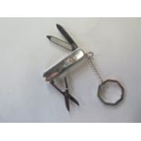 A Tiffany and Co silver and white gold penknife key ring, marked 925/750 Victorinox blade,