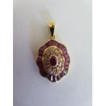 A ruby and diamond 18ct yellow gold pendant with with a central oval ruby surrounded by sixteen