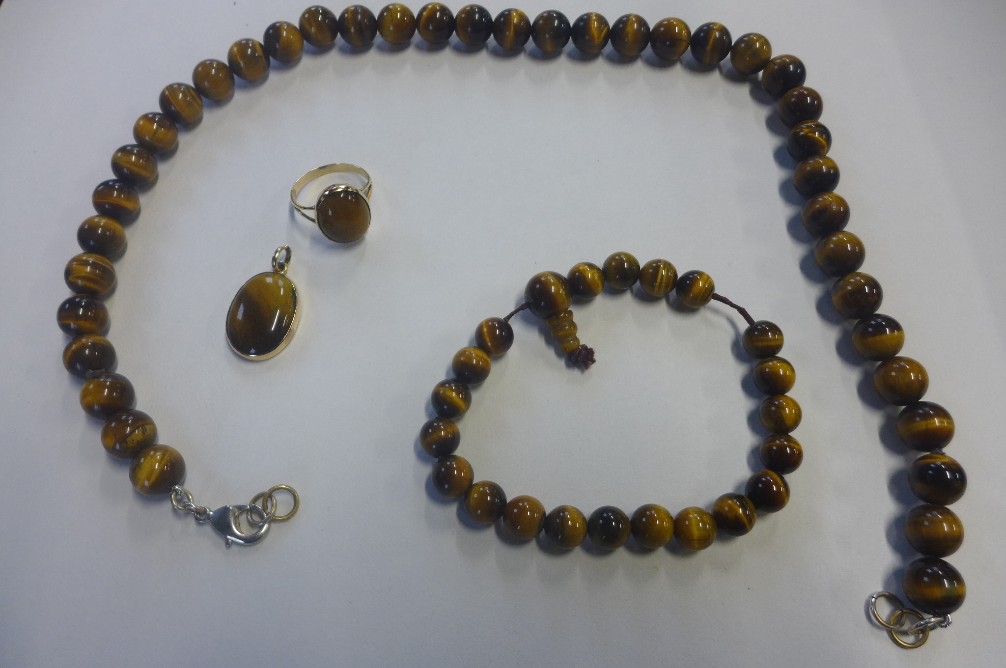 A gold and tigers eye pendant, gold and tigers eye ring, tested as 18ct, pendant measures 12mm in