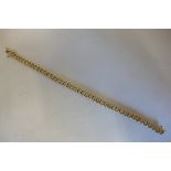 A yellow gold and diamond tennis bracelet, the gold tested to 9ct but the bracelet is not