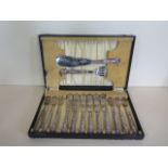 A boxed six setting fish cutlery set with silver handles, generally good, box worn
