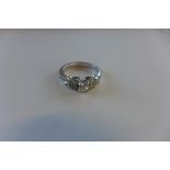 A hallmarked 18ct diamond ring, the central brilliant cut diamonds with shaped diamond encrusted