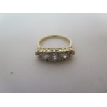 An 18ct yellow gold Edwardian five stone diamond ring, interspersed with eight smaller diamonds,