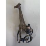 An interesting cold painted bronze figure of three children climbing a giraffe, 10cm tall, some