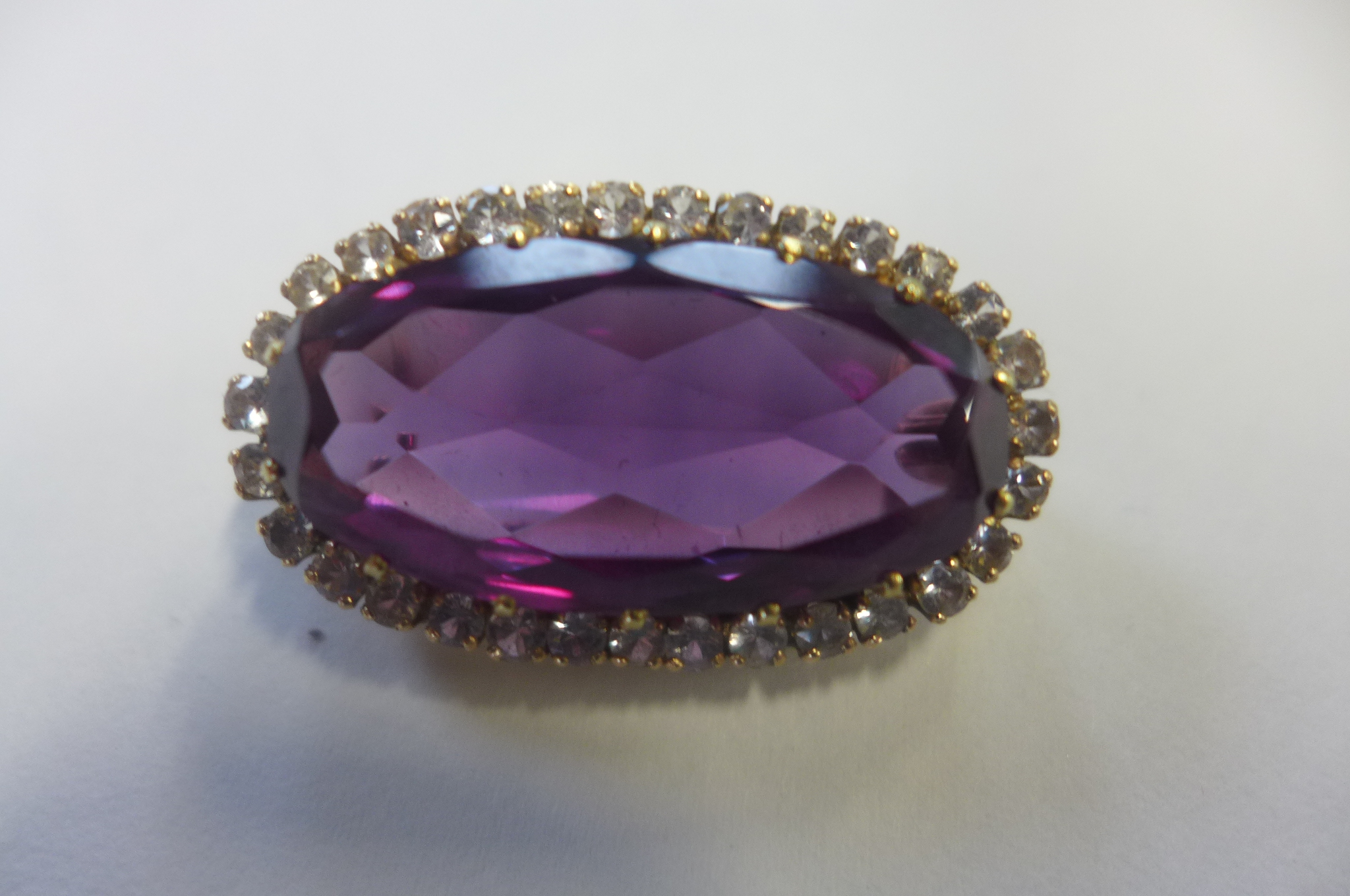 A 9ct gold amethyst and white stone brooch, not hallmarked but stamped 9ct to pin and tests as