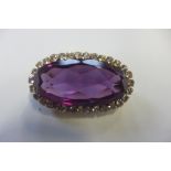 A 9ct gold amethyst and white stone brooch, not hallmarked but stamped 9ct to pin and tests as