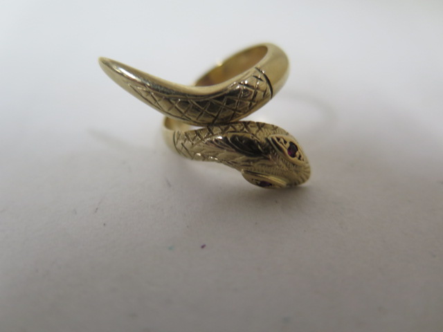 A 9ct yellow gold snake ring, single, coil with textured head and tail detail, set with two