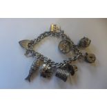 A silver charm bracelet set with various charms, approx 56 grams