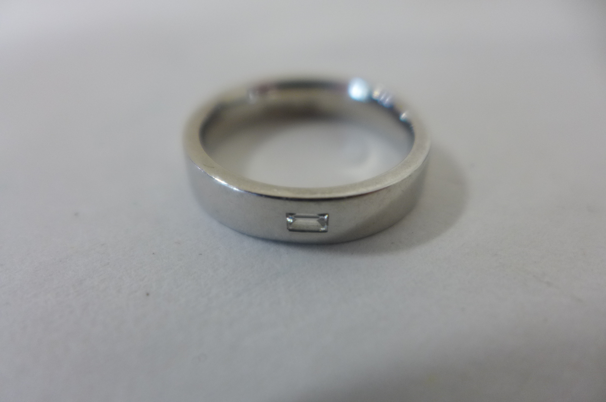 A platinum and diamond ring, size L, approx 7.9 grams, some marks consistent with usage