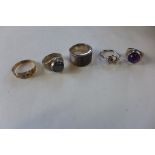 A gold ring, not hallmarked, approx 2.5 grams, tests to approx 9ct, and four white metal rings,