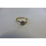An 18ct gold and platinum diamond set daisy ring, set with seven small round cut diamonds, in a