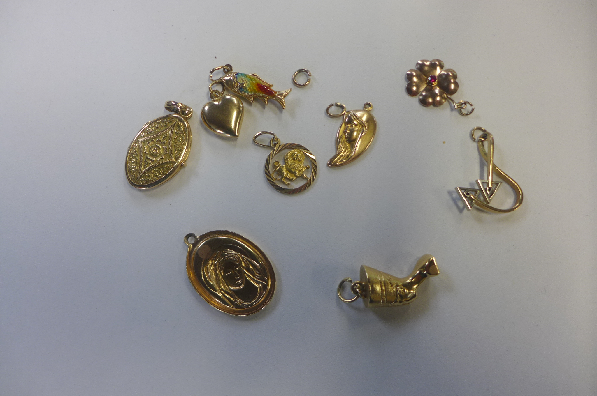 Nine 18ct gold charms, none carry British hallmarks, some stamped 750, all tested to 18ct or