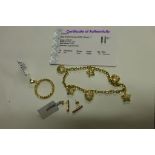 A 9ct yellow gold pendant, a pair of 9ct gold ruby earrings and a 9ct charm bracelet, total weight