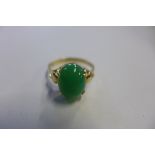 A yellow jade ring, stamped 18k but tested to 9ct or above, the cabachon polished jade stone