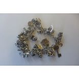 A silver charms bracelet set with various charms, approx 60 grams