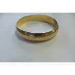 An 18ct gold bangle with Arabic hallmarks and stamped 750, tested as 18ct or above, intricate