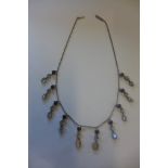 A vintage silver necklace, set with multiple moonstone and garnet drops