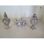 A silver embossed three piece cruet set, hallmarked Birmingham 1909 - by Joseph Glostor Ltd,